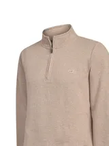 Buzo de hombre con medio cierre frontal y cuello alto, confeccionado en algodón orgánico con interior de french terry. Presenta un diseño liso en color taupe con un pequeño logo bordado en el pecho.
