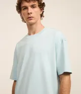 Remera de corte relajado, confeccionada en algodón de gramaje grueso con cuello redondo y mangas cortas.