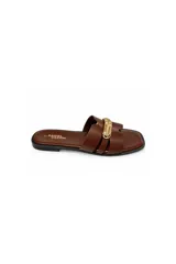 Sandalia plana Daniel Cassin modelo Poma, de color marrón con tiras cruzadas y un aplique metálico dorado en el centro. Presenta diseño de punta cuadrada.