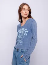 Remera de manga larga confeccionada en tela tipo waffle, con cuello redondo y estampa desgastada en el frente.