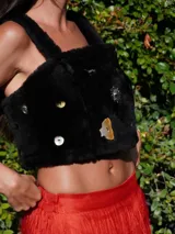 Top negro de corderito natural con breteles y broches en la espalda. Decorado con pins variados.