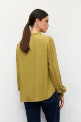 Camisa blanca de manga larga con puños elastizados, cuello mao y escote en v, botones forrados en la misma tela.