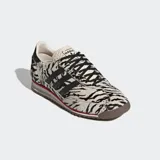 Championes Adidas modelo SL 72 OG con diseño de estampado animal print tipo cebra en material de pelo sintético. Presentan las icónicas tres tiras laterales en color negro, detalle de línea roja en la mediasuela y suela de caucho.