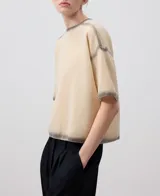 Jersey de punto extrafino color beige con efecto spray gris en cuello, mangas y ruedo.