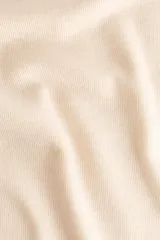 Top entallado de punto fino en color beige, con cuello alto, mangas japonesas y bajo recto.