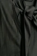 Camisa de corte holgado confeccionada en tejido satinado con mezcla de lyocell. Presenta cuello redondo con escote en pico y lazada frontal integrada. Cuenta con mangas largas abullonadas terminadas en puños anchos y bajo recto.