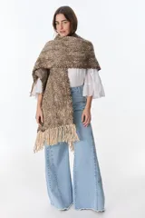 Ruana artesanal tejida en telar con lana hilada a rueca por tejedoras rurales de Uruguay. Diseño con patrón a cuadros en tonos marrón y crudo, con flecos en los extremos.