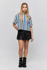 Short negro de PU con diseño tipo falda en la parte delantera, tiro medio y cierre lateral invisible.
