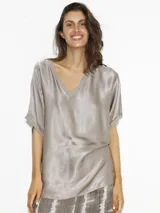 Remera color gris plata de seda sintética, con escote en V y mangas cortas.