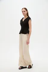 Blusa de lino color blanco, con cuello en V, pinzas de entalle y diseño al cuerpo con faldón acampanado.