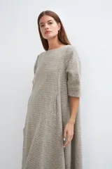 Vestido midi acampanado de lana fina sin teñir, con cuello bote, mangas tres cuartos con tajo y bolsillos laterales. Diseño forrado con vuelo y movimiento.