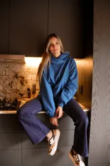 Canguro azul con capucha y logo de flor bordado en verde.