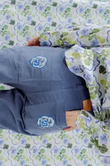 Pantalón de jean azul con bolsillos frontales y traseros. Presenta bordados de flores en los bolsillos traseros.