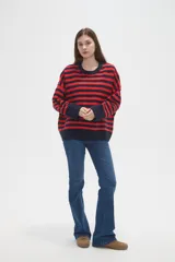 Sweater de tejido de punto con diseño de rayas horizontales en color rojo y azul marino, cuello redondo a la base y mangas largas con corte holgado.