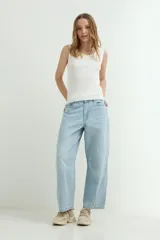 Pantalón jean de corte balloon, color celeste claro, tiro medio y diseño amplio en las piernas con costuras en las rodillas.