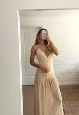 Vestido largo de fiesta color amarillo pastel, confeccionado en microtul con doble tela en la parte superior. Tiene breteles finos y escote en V.