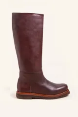 Bota de caña alta confeccionada en cuero vacuno, con diseño minimalista y suela de goma texturizada.