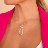 Conjunto de cadena y dije doble en plata 925. El dije superior es un óvalo pequeño pavé con circonias, y el dije inferior es un óvalo grande de plata lisa con acabado pulido.