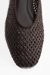 Ballerinas marrones de material sintético trenzado, con diseño de punta redondeada y suela plana.