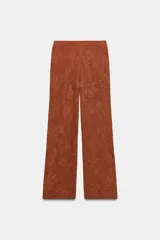 Pantalón largo de tejido calado color terracota, con tiro alto y pierna ancha.