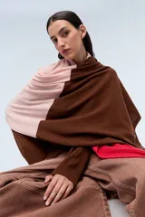 Ruana tejida de punto con bloques de color rosa y marrón. Confeccionada en lambswool.