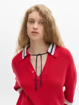 Sweater marrón de punto con cuello polo, escote en V y mangas largas con puños acanalados.