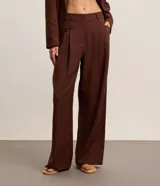 Pantalón wide leg de sastrería y cintura alta en color marrón, confeccionado en mezcla de viscosa y lino, con pliegues frontales y trabillas para cinturón.