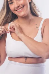 Soutien maternal sin aro, color blanco, diseñado con doble clip en los breteles para facilitar la lactancia y el uso de extractor. Presenta un escote alto, breteles elásticos regulables y cierre de broches en la espalda.