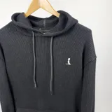 Canguro negro oversize de tejido con capucha y cordones.