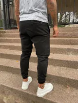 Pantalón babucha negro de gabardina con cintura elástica y bolsillos laterales.