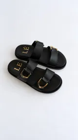 Sandalias de horma anatómica color marrón, confeccionadas en cuero texturado, con dos tiras anchas ajustables mediante hebillas metálicas doradas.