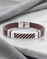 Pulsera compuesta por una banda de acero inoxidable con diseño calado geométrico y una correa de cuerina trenzada en color marrón.