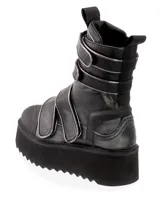 Bota de caña media color negro con plataforma dentada. Presenta un diseño de cuero con múltiples tiras ajustables con velcro y bordes metalizados, puntera reforzada y tiradores en la parte superior.