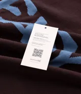 Suéter de punto en jacquard color bordó con diseño de cuello polo y cierre frontal parcial. Presenta estampado frontal con la palabra 'EASY' y la frase 'plans being' en color celeste, además de un pequeño logo bordado. Posee mangas largas con puños acanalados y un corte holgado.