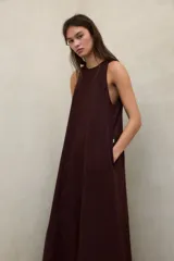 Vestido largo blanco de lino ligero, sin mangas, con cuello redondo y silueta fluida.