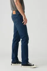 Pantalón de jean azul oscuro, corte slim fit, tiro medio y confeccionado en tejido rígido.