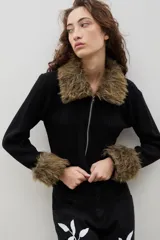 Saco tejido de algodón en color negro, con cierre frontal y detalles de piel sintética en cuello y puños.