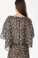 Blusa de lino italiano color blanco, con diseño holgado, escote asimétrico estilo off-shoulder y mangas cortas amplias.