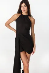 Vestido corto de lino celeste, con escote halter, falda drapeada asimétrica y cierre invisible en el lateral.