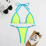 Bikini de dos piezas con corpiño triangular y bombacha colaless. El diseño destaca por sus detalles de cadenas doradas con perlas incrustadas en los breteles del corpiño y en los laterales de la bombacha. Presenta una combinación de colores vibrantes en amarillo y naranja.
