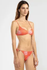 Bottom de bikini estilo triángulo, confeccionado en tejido reciclado con estampado pinstripe floral en tonos rojos y rosados. Presenta tiras ajustables a los laterales con terminaciones metálicas insignia de Polonio y forro interior para mayor comodidad.