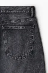 Pantalón de jean de cinco bolsillos, confeccionado en denim de algodón rígido. Modelo de corte baggy, holgado desde la cadera hasta el bajo, con piernas redondeadas extraamplias y pliegues en el tobillo. Presenta cintura clásica con cierre y tiro bajo.