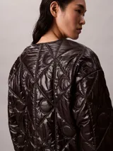 Campera acolchada Calvin Klein de color negro, con diseño matelasseado con monogramas, cuello redondo y cierre frontal de cremallera.