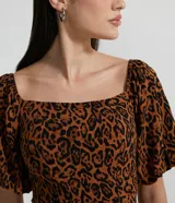 Vestido corto de viscosa con estampado animal print en tonos marrón y negro. Presenta escote cuadrado y mangas cortas abullonadas.