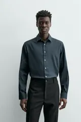 Camisa de hombre color beige claro, de corte slim fit, con cuello italiano, manga larga y cierre frontal de botonadura.