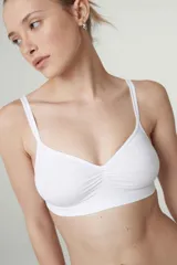 Soutien tipo bralette de microfibra sin costuras, con diseño de doble bretel regulable y detalle fruncido en el centro del escote. Cuenta con cierre de broche doble en la espalda con tres niveles de ajuste.