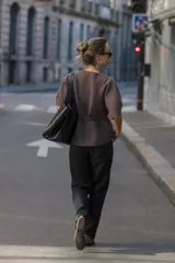 Jersey de punto color marrón, con cuello redondo, mangas cortas abullonadas y detalle de lazo frontal en la cintura.