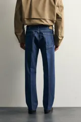 Jeans de denim azul oscuro sin lavados, corte recto con raya frontal planchada, tiro medio, cinco bolsillos y cierre frontal de botonadura. Colección especial Aaron Levine x Zara.