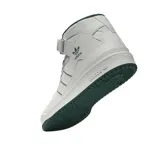 Championes adidas Forum Mid de corte medio, color blanco con detalles en verde oscuro en el cuello, las tres tiras laterales, el logo del trébol y la suela. Presentan cierre de cordones y tira de velcro en el tobillo.