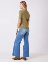 Buzo tejido marca Tahari, color verde, con cuello a la base, manga corta y diseño de ochos en el frente.